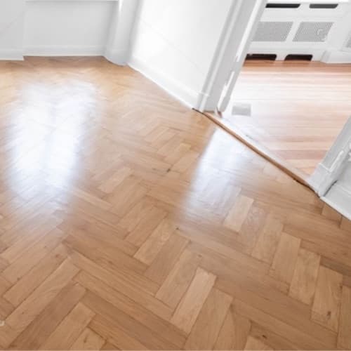 The same parquet floor, polished and gleaming, after an A+ clean